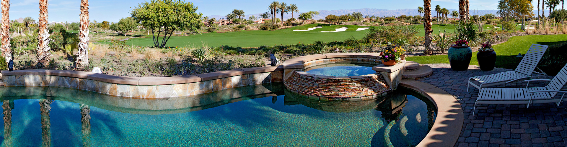 hot tub and pool beautifully landscaped with a view of a golf course in the background