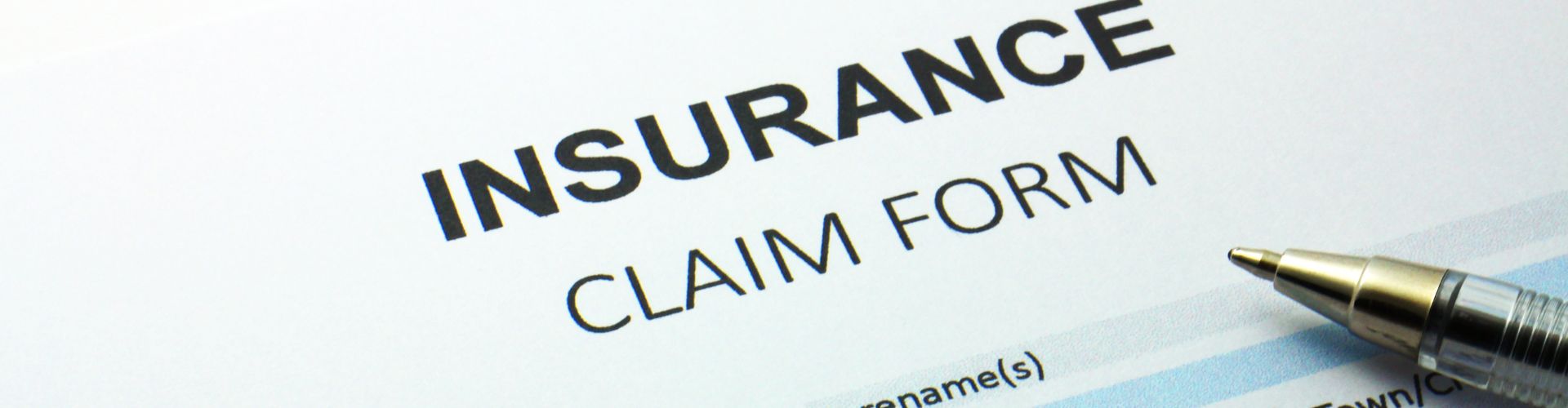 blank insurance claim form with a pen